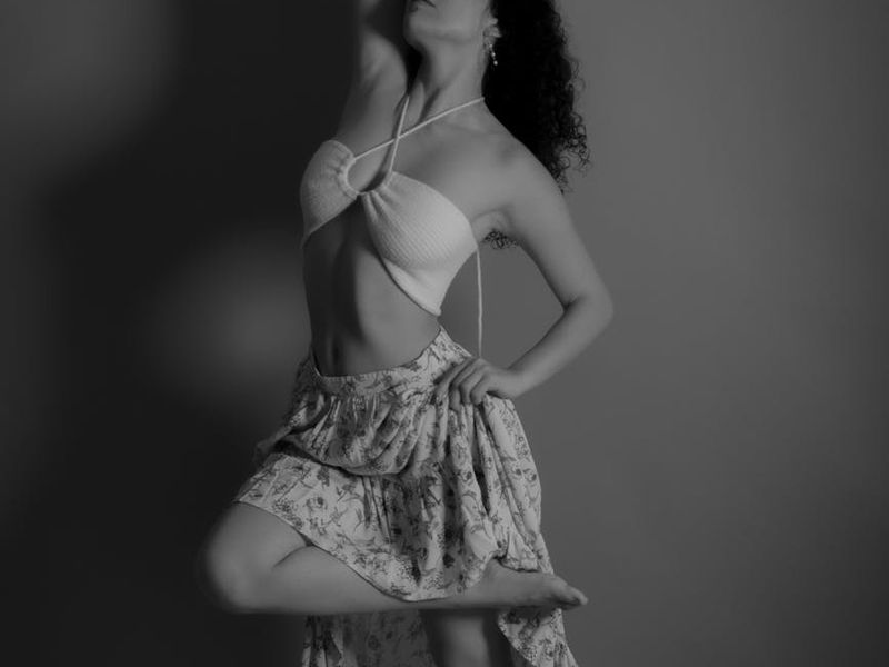 A person performing a flowing movement in a bright, open studio.