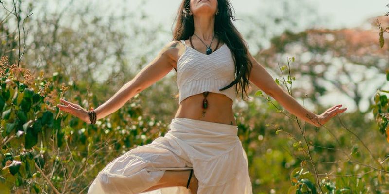 Person holding a balanced pose on one leg with arms outstretched.